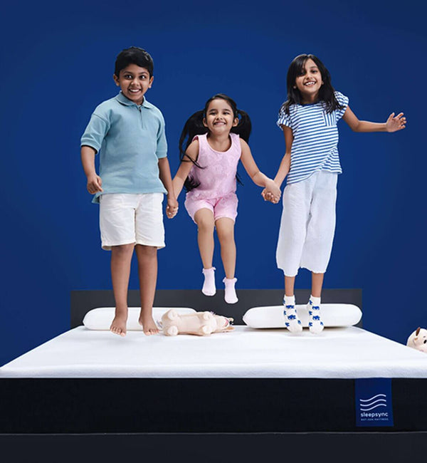 Three joyful children jumping on a bed mattress, showcasing fun and comfort in a playful setting.